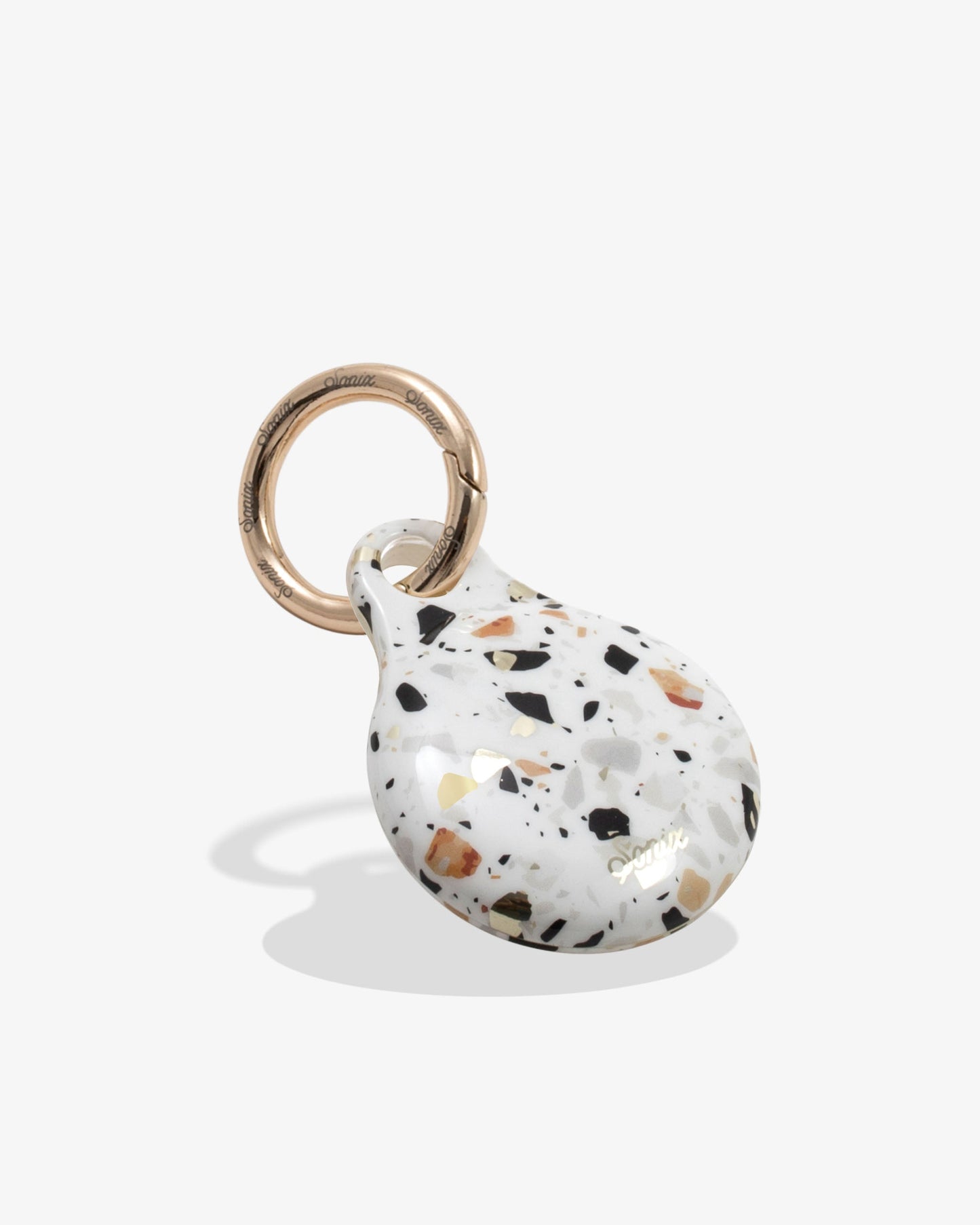 confetti air tag with gold ring with whites, blues, oranges, and black