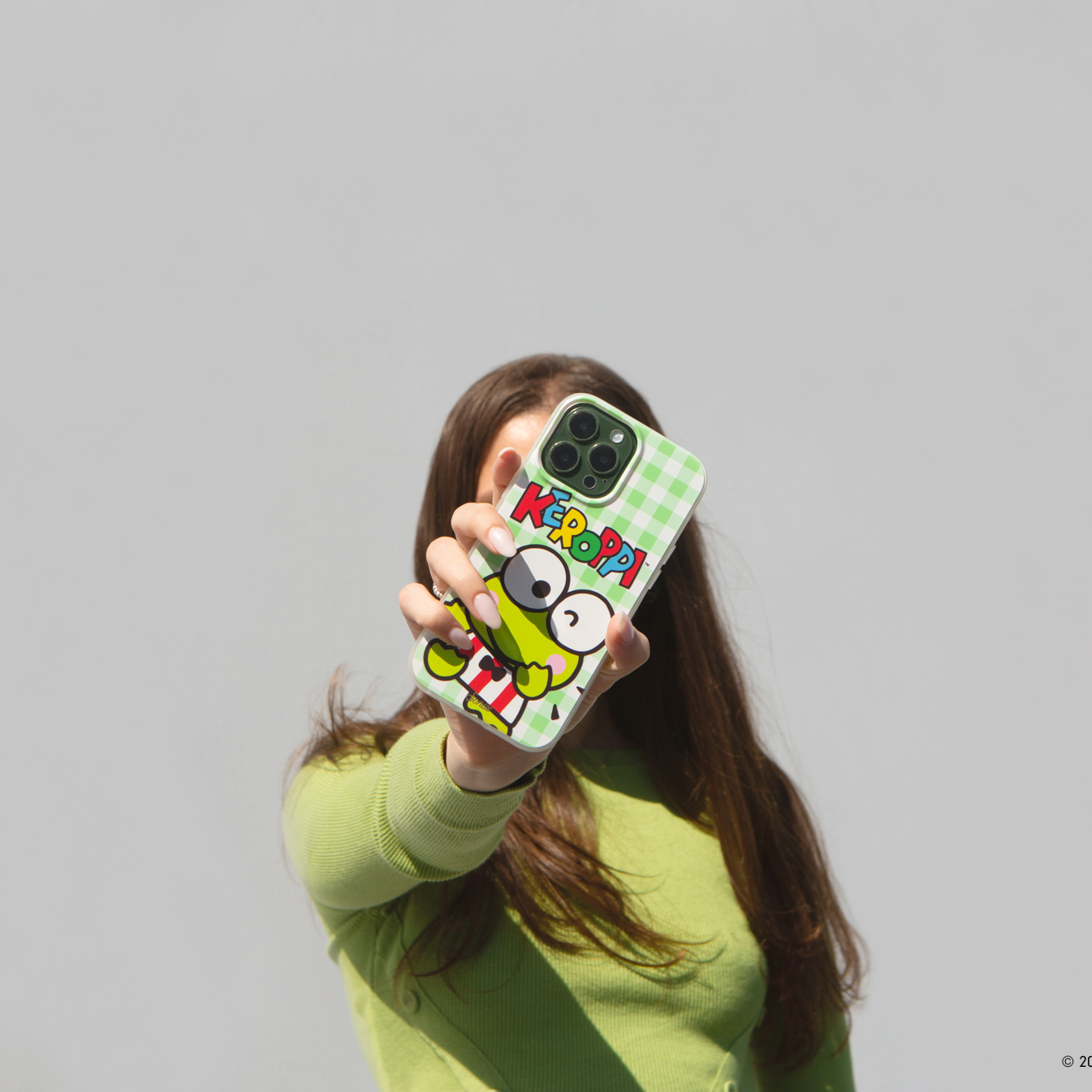 girl with brown hair in green sweater holding keroppi smiles magsafe compatible iphone case