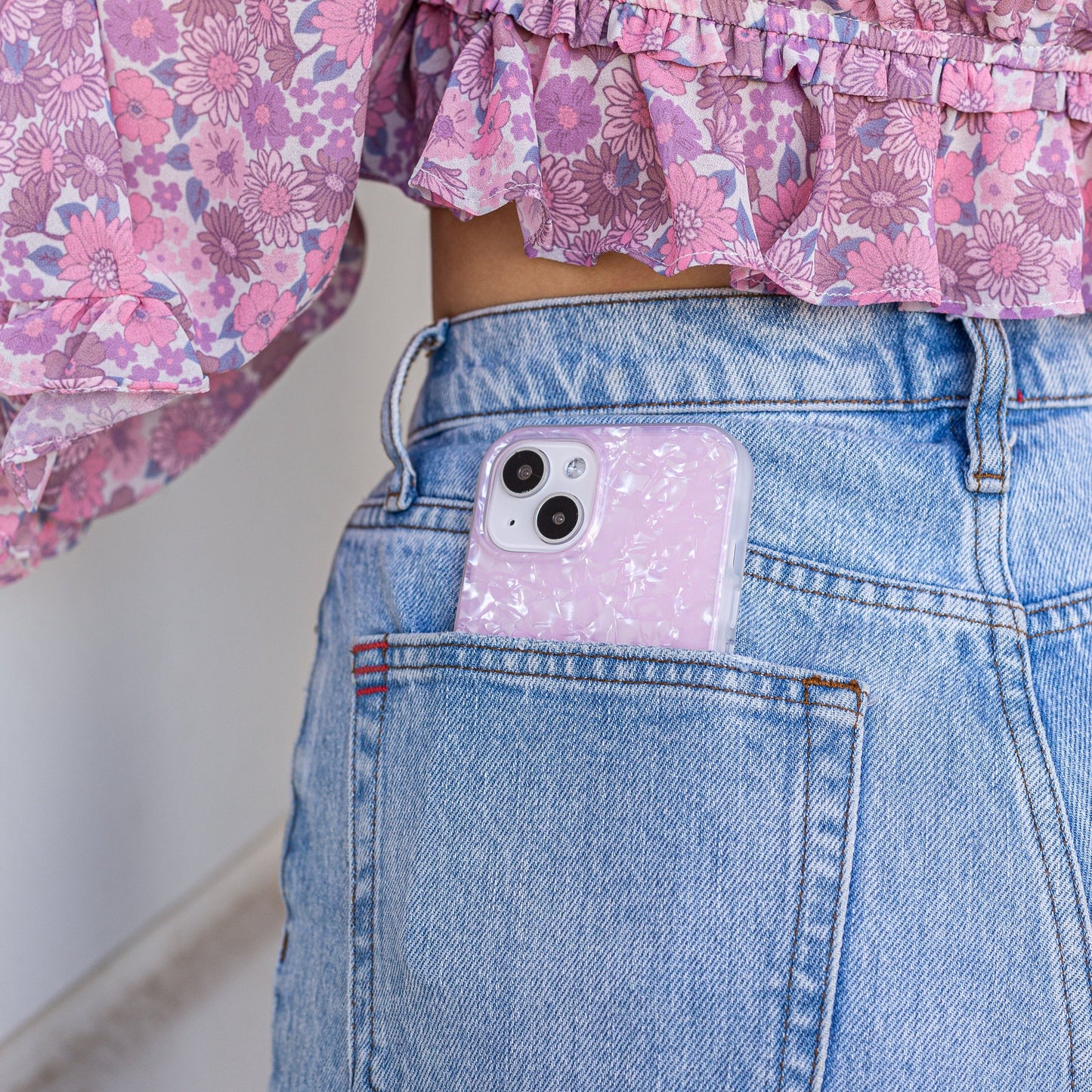 tort design with a shine that gleams in the light shown on an iphone in the back pocket of a girls jeans