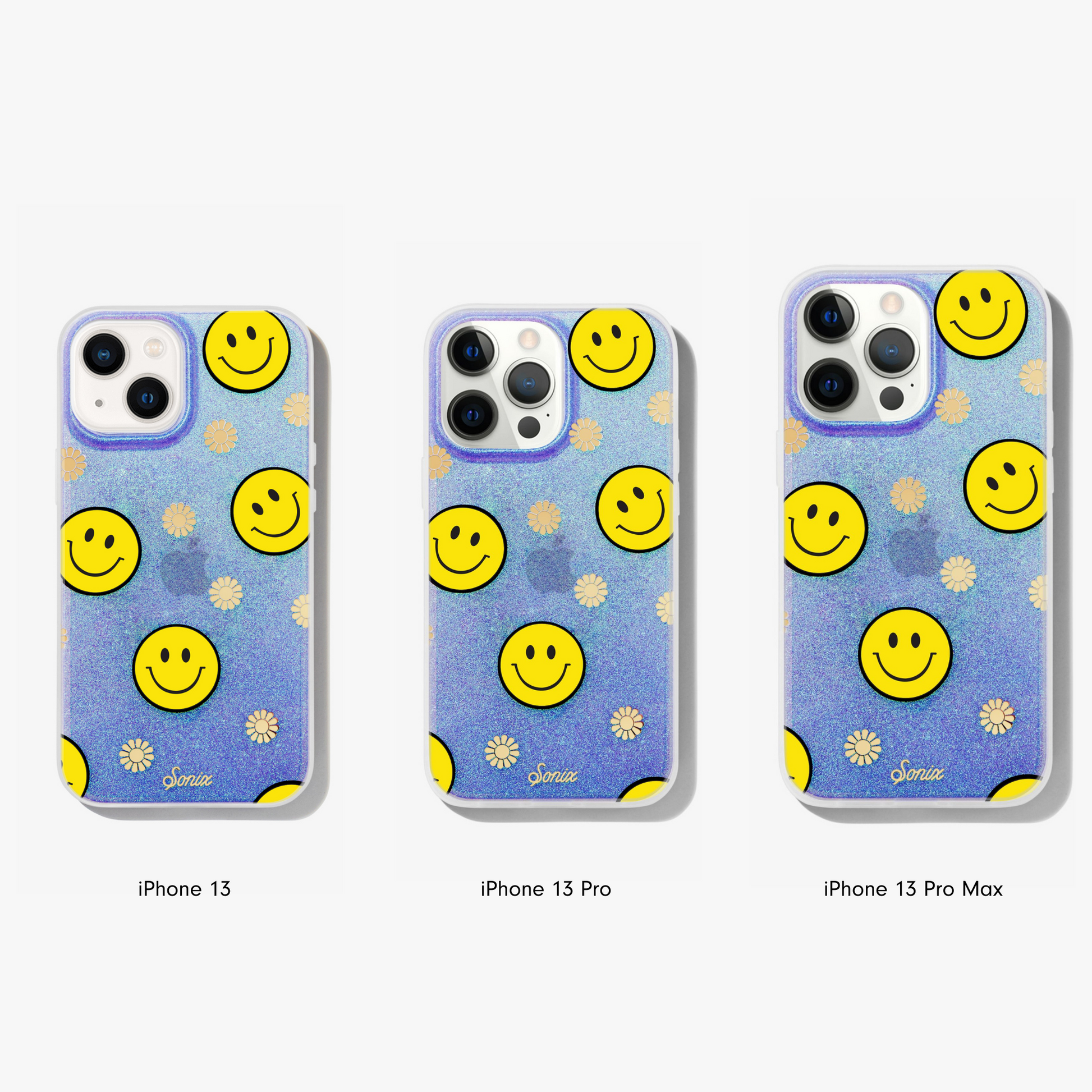 The clear purple case infused with iridescent glitter features happy faces and signature gold foil flowers shown on an iphone 13, iphone 13 pro, and an iphone 13 pro max