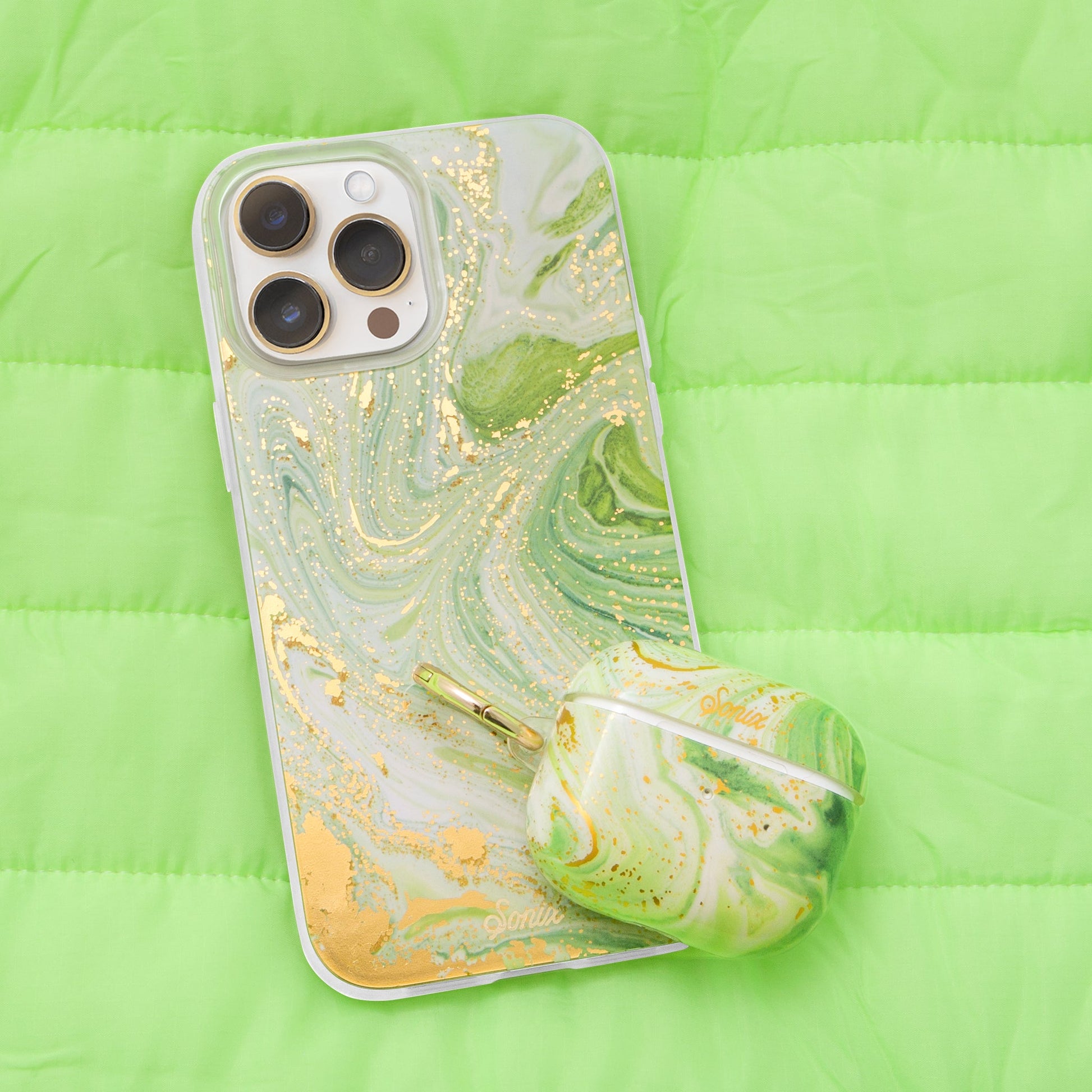 jade green marbled design with gold shimmer detailing shown on an iphone 12 and airpod case
