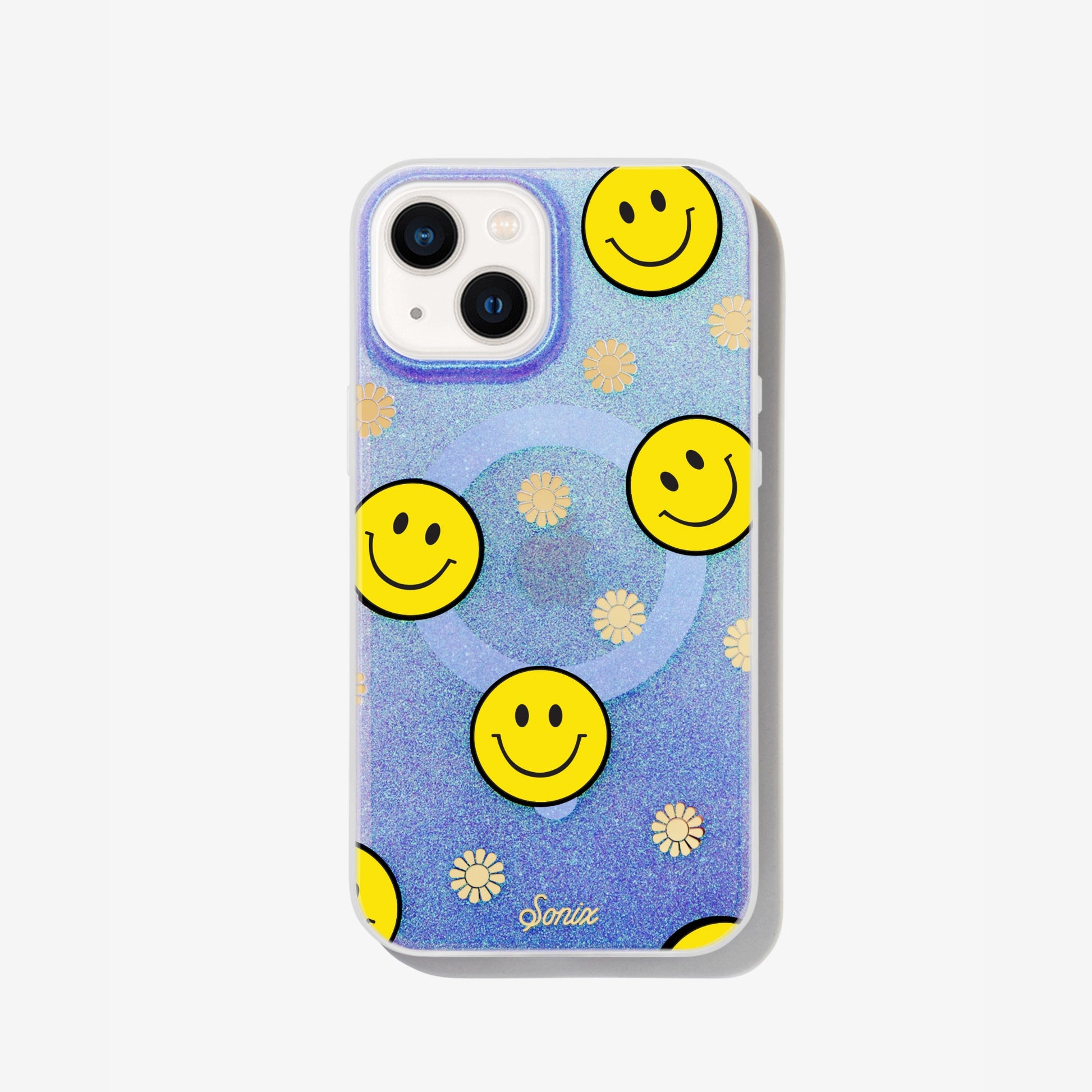 The clear purple case infused with iridescent glitter features happy faces and signature gold foil flowers shown on an iphone 12 