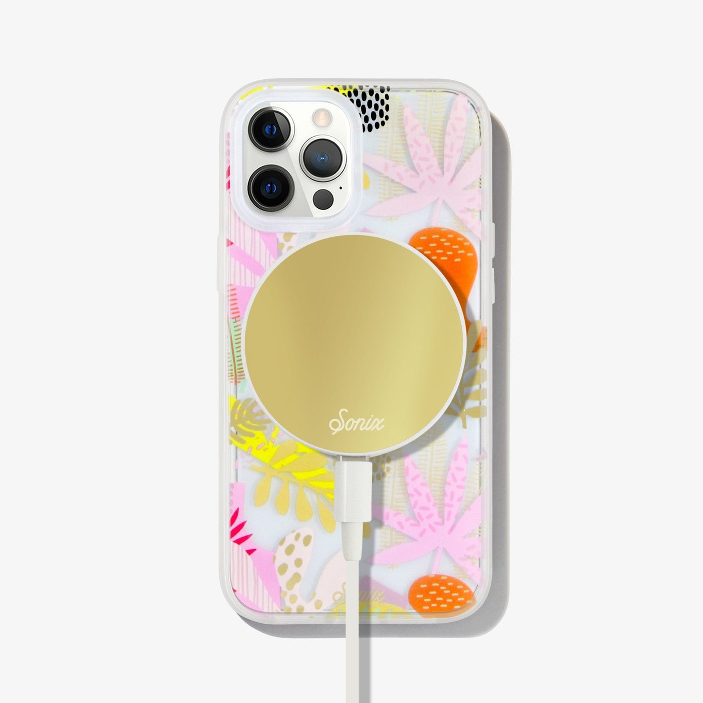 a collection of earthy shapes and forms, like plants and flowers to create a composition of playful abstract art with gold foil details shown on an iphone 12 pro with a gold maglink charger on the back